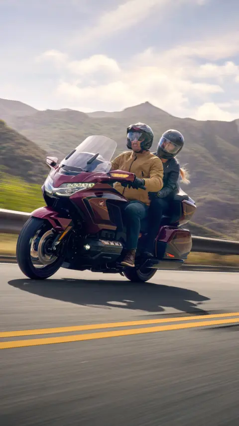 Dois indivíduos numa Honda GL1800 Gold Wing Tour, fundo de montanha.